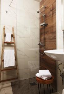un bagno con lavandino e doccia con asciugamani di Eagle’s Nest Hostel a Postumia Altre 30 foto