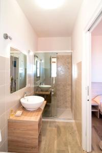 a white bathroom with a sink and a shower at MOLAROTTO CAMERE CON ANGOLO COTTURA in San Teodoro