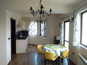 een keuken en eetkamer met een tafel en stoelen bij Apartments in Golden Sands park near the sea in Varna