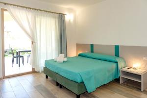 a bedroom with a bed and a large window at MOLAROTTO CAMERE CON ANGOLO COTTURA in San Teodoro