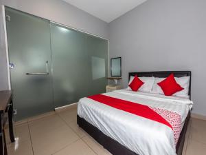 ein Schlafzimmer mit einem großen Bett mit roten Kissen in der Unterkunft OYO 1185 Ho Hotel in Malakka
