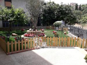 a fence with a bicycle in a garden with a fountain at A casa di Simona in Monreale