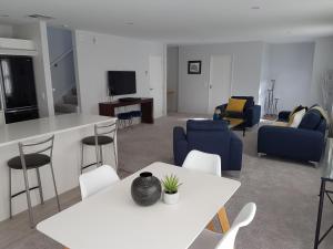 sala de estar con mesa blanca y sillas en Delightful Petone Townhouse en Lower Hutt