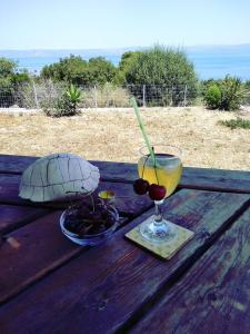 a drink and a turtle on a wooden table at Ktima Kiourelioti in Skála Sykaminéas