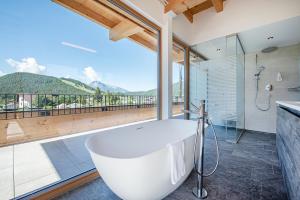 a bath tub in a bathroom with a large window at GOTTHARD - FINE LIVING APARTMENTS in Seefeld in Tirol