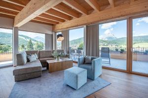 a living room with a couch and chairs and windows at GOTTHARD - FINE LIVING APARTMENTS in Seefeld in Tirol