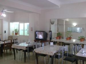 a dining room with tables and chairs and a tv at Real Splendid Hotel in Buenos Aires