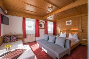 salon z kanapą i łóżkiem w obiekcie Gasthof Zellerstuben w mieście Zell am Ziller