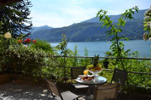 a table and chairs with a view of a lake at Villa Rina Deluxe and Cottage in Porto Ceresio