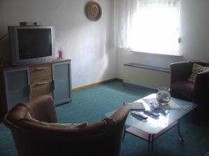 a living room with a tv and a table and chairs at Ferienwohnung Lindlar in Lindlar