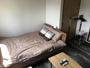 a bed in a room with a coffee table at コンドミニアムホテル Stay inn Blue in Hukue