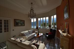 a living room with couches and a chandelier at Villa Rina Deluxe and Cottage in Porto Ceresio
