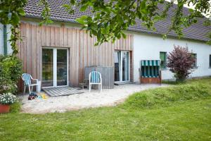 two chairs sitting on a patio in front of a house at Reiterhof Zwei Linden in Melle