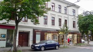 a blue car parked in front of a building at Sonnberg Design Apartment in Vienna