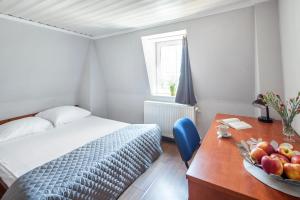 グディニャにあるSleepy3city Apartments Abrahama 16のベッドルーム1室(ベッド1台、テーブル、フルーツボウル付)