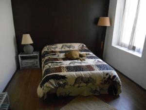 misia siedzącego na łóżku w sypialni w obiekcie attitude zen w mieście Saint-Laurent-le-Minier