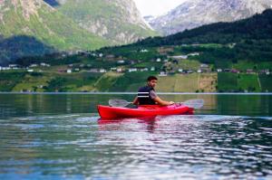 a man sitting on a red kayak on a lake at Fjord House in Grimo