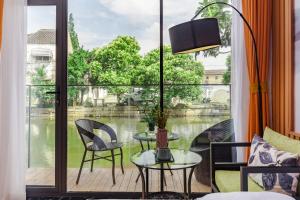苏州Tongli Slowlife River View Inn的阳台配有桌椅和大窗户。