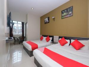 a hotel room with two beds with red pillows at Super OYO 1152 Heaven Hill 2 in Cameron Highlands