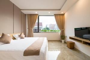 une chambre avec un grand lit et une télévision à écran plat dans l'établissement Hoài River Hội An Homestay Sông Hoài Homestay 250m walk to the center Old Town, à Hội An 70 autres photos