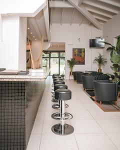 un bar con sgabelli neri in sala d'attesa di Argentario Lagoon Resort & Spa a Monte Argentario