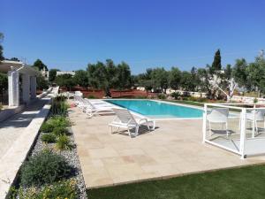 a patio with chairs and a swimming pool at Trullo Genesi in Cisternino