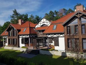 a large house with a red roof at DWÓR U PAPUGA in Ruciane-Nida