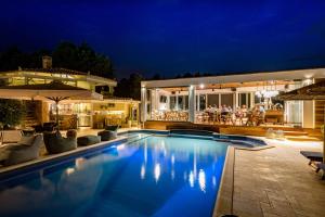 a swimming pool in front of a house at night at Anthemion Suites and Villas in Nafplio