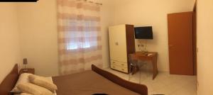 a living room with a bed and a tv in it at Villa Donatella in Paestum