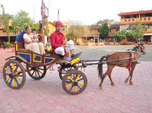 a group of people riding on a horse drawn carriage at Nakhrali Dhani Resort in Indore