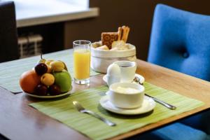 un tavolo con colazione a base di frutta e un bicchiere di succo d'arancia di Arbat Hotel a Chelyabinsk