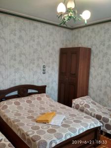 1 dormitorio con 2 camas y lámpara de araña en Kontinental Guest House, en Anapa