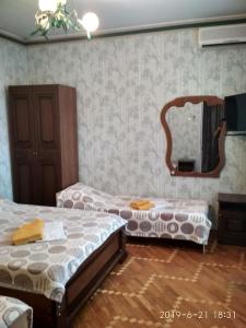 1 dormitorio con 2 camas y espejo en Kontinental Guest House, en Anapa