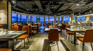 a restaurant with tables and chairs and windows at Stella Maris Beach Danang in Da Nang