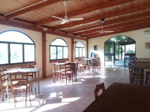 a dining room with tables and chairs and windows at Punto Verde B&B in Ardore Marina