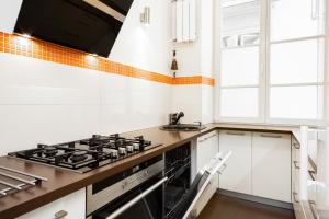 a kitchen with a stove and a sink at Apartments Warsaw Świętojańska by Renters in Warsaw