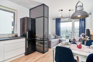 a kitchen and living room with a black refrigerator at Apartments Wrocław Małopanewska in Wrocław