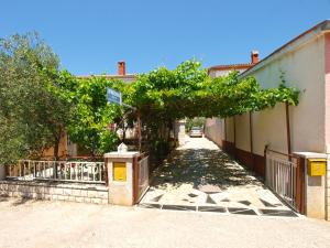 uma rua com uma cerca e um portão com árvores em Apartments Petar 1306 em Barbariga