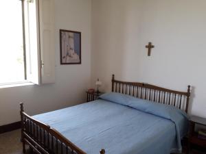 una camera da letto con un letto con una croce sul muro di Appartamento in Villa Venezuela piano Terra a Porto di Maratea