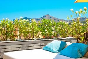 a bed with two blue pillows on a balcony at Cas Ferrer Nou Hotelet in Alcudia