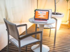 a laptop computer sitting on a white table with a chair at Cas Ferrer Nou Hotelet in Alcudia