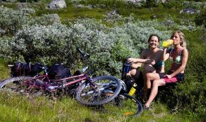 Lia Fjellhotell في جيلو: جلستا سيدتان بجانب دراجة في ميدان