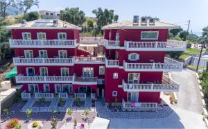 Luftblick auf ein rotes Gebäude mit weißen Balkonen in der Unterkunft Hotel Parga Princess in Parga