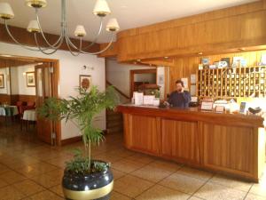 Un uomo in piedi al bancone di un ristorante di Hotel Edelweiss a Villa General Belgrano