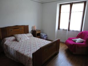 a bedroom with a bed and a chair and a window at Gite CLEVACANCES in Laval-du-Tarn