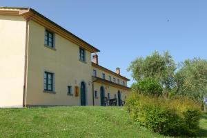 una gran casa blanca con un patio de césped en Agriturismo Musignano, en Cerreto Guidi