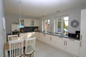 een keuken met witte kasten en een tafel en stoelen bij Landhaus Scholz in Dollerup