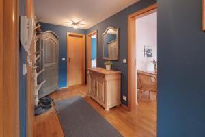 a hallway with blue walls and a room with a dresser at Die Edelraute in Oberstdorf