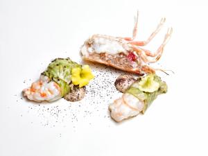 a meal of shrimp and vegetables on a white background at Cas Ferrer Nou Hotelet in Alcudia