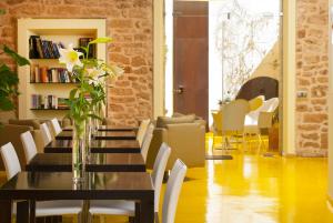 a dining room with a table with a vase of flowers at Cas Ferrer Nou Hotelet in Alcudia